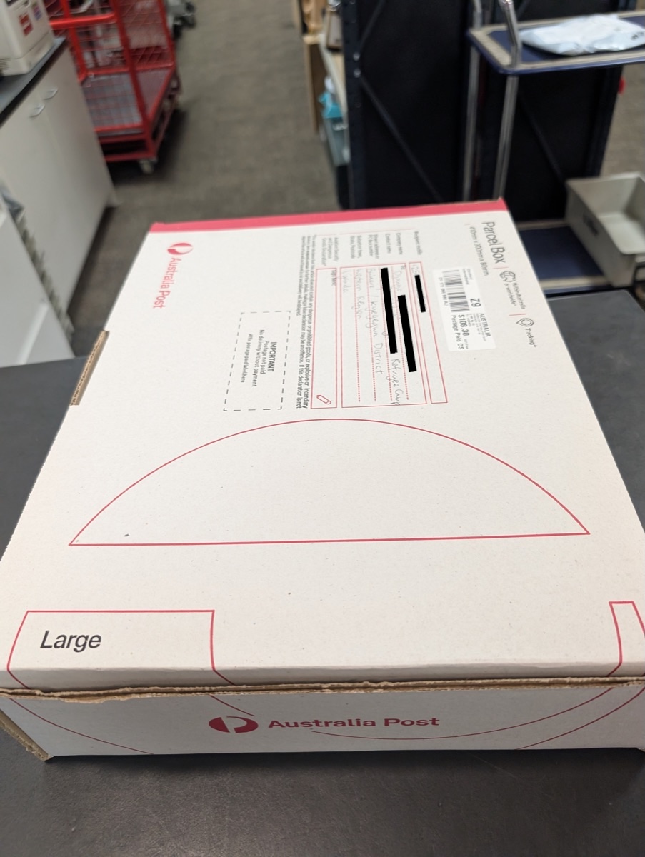 Australia Post staff helping package up the laptop for international shipping